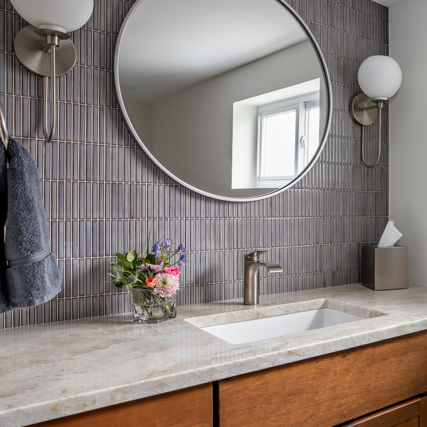 Hinsdale bathroom remodel featuring quartzite counter, custom backsplash with circular mirror and sconces