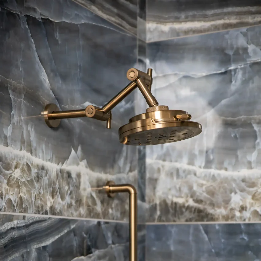 Bathroom with a brass articulating showerhead and marble tile