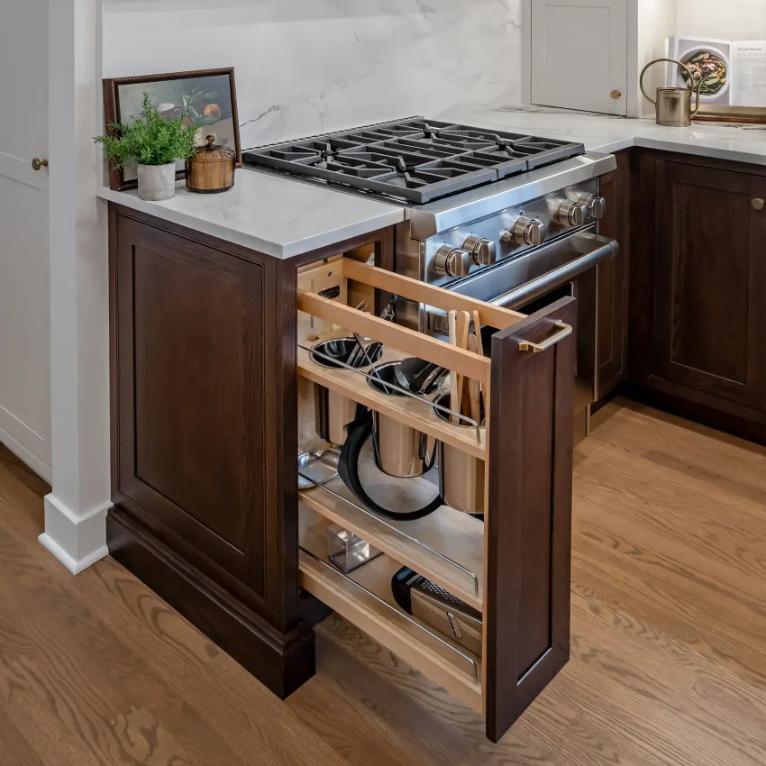 Kitchen with a dark wood island, white marble countertops and a gas range