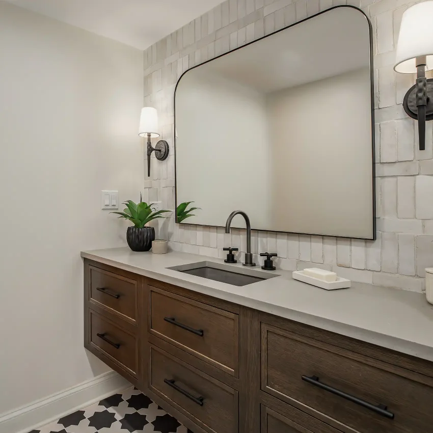 Bathroom with a walnut vanity, white subway tile and rounded mirror